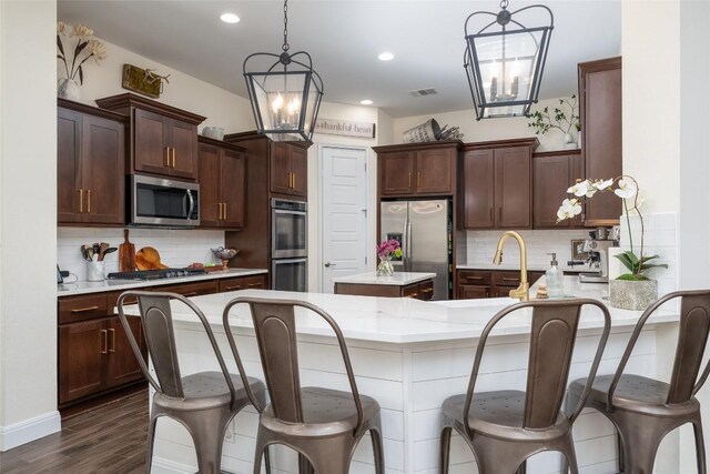1225 Grassy Field Rd, Austin, TX 78737 - kitchen with stainless steel appliances, a chandelier, decorative backsplash, dark brown cabinets, and recessed lighting