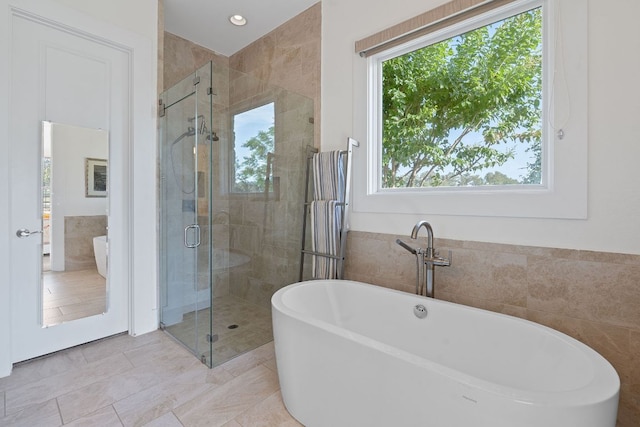 260 Unbridled, Austin, TX 78737 - bathroom featuring a soaking tub, a stall shower, tile walls, and tile patterned floors