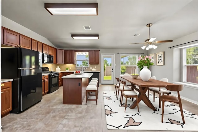 2128 Pearson Way, Round Rock, TX 78665 - kitchen featuring black appliances, light countertops, a kitchen breakfast bar, a ceiling fan, and tasteful backsplash