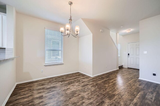 137 Green Egret Way, Leander, TX 78641 - unfurnished dining area with dark wood-type flooring, a chandelier, and baseboards