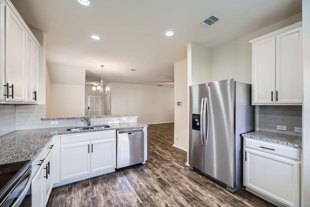 137 Green Egret Way, Leander, TX 78641 - kitchen featuring stainless steel appliances, a sink, white cabinetry, dark wood-style flooring, and a peninsula