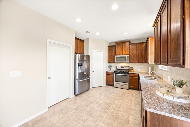 313 Pearl Way, Buda, TX 78610 - kitchen featuring appliances with stainless steel finishes, brown cabinets, recessed lighting, backsplash, and light tile patterned flooring