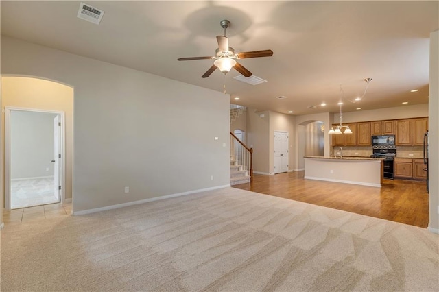 1911 Nelson Ranch Loop, Cedar Park, TX 78613 - unfurnished living room featuring light colored carpet, arched walkways, stairs, ceiling fan, and recessed lighting