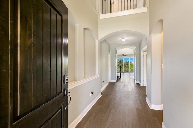 3908 Crispin Hall Ln, Pflugerville, TX 78660 - foyer entrance featuring arched walkways, dark wood finished floors, baseboards, and ceiling fan