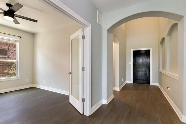 3908 Crispin Hall Ln, Pflugerville, TX 78660 - foyer entrance featuring dark wood-style floors, arched walkways, ceiling fan, and baseboards