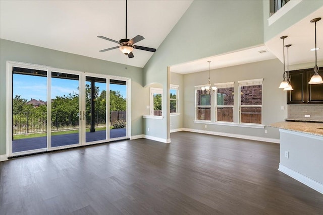 3908 Crispin Hall Ln, Pflugerville, TX 78660 - unfurnished living room featuring ceiling fan, high vaulted ceiling, baseboards, dark wood finished floors, and a chandelier