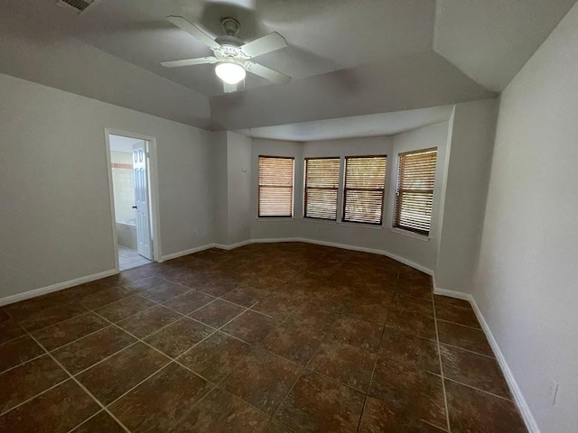 5001 Blue Bluff Rd, Austin, TX 78724 - spare room with a ceiling fan, baseboards, dark tile patterned floors, and vaulted ceiling