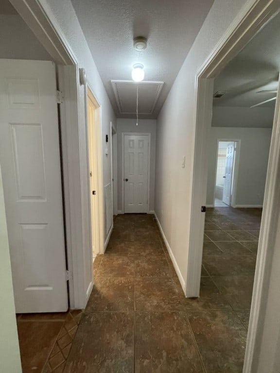 5001 Blue Bluff Rd, Austin, TX 78724 - corridor with attic access, baseboards, and dark tile patterned floors