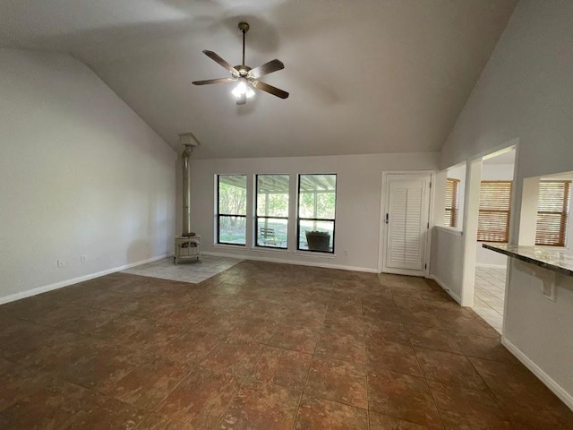 5001 Blue Bluff Rd, Austin, TX 78724 - unfurnished living room with a wood stove, a ceiling fan, baseboards, and high vaulted ceiling
