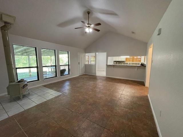 5001 Blue Bluff Rd, Austin, TX 78724 - unfurnished living room with ceiling fan, baseboards, high vaulted ceiling, and a wood stove