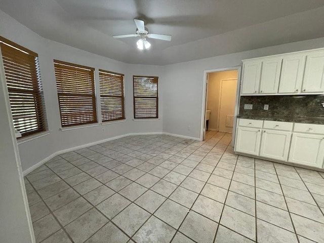 5001 Blue Bluff Rd, Austin, TX 78724 - kitchen with ceiling fan, backsplash, light tile patterned floors, dark countertops, and white cabinetry