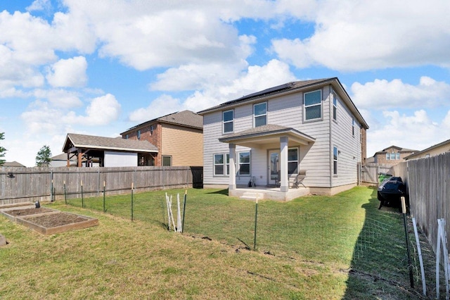 18909 James Carter Jr St, Manor, TX 78653 - rear view of house with a garden, a fenced backyard, a patio, and solar panels