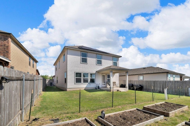 18909 James Carter Jr St, Manor, TX 78653 - back of house featuring a vegetable garden, solar panels, a patio area, and a fenced backyard