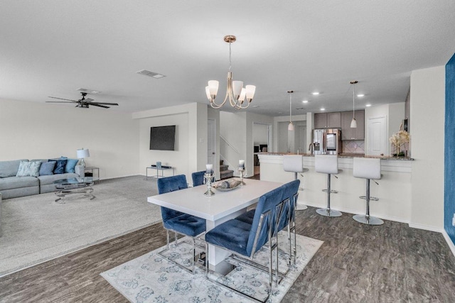 18909 James Carter Jr St, Manor, TX 78653 - dining space with dark wood finished floors, a chandelier, ceiling fan, recessed lighting, and stairs
