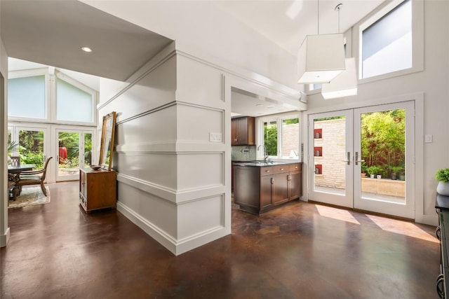 4305 Cliffwood Cir, Austin, TX 78759 - kitchen with finished concrete flooring, high vaulted ceiling, french doors, tasteful backsplash, and decorative light fixtures
