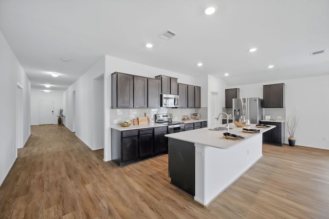 601 Sassafras St, Hutto, TX 78634 - kitchen with stainless steel appliances, a sink, light countertops, light wood-type flooring, and recessed lighting