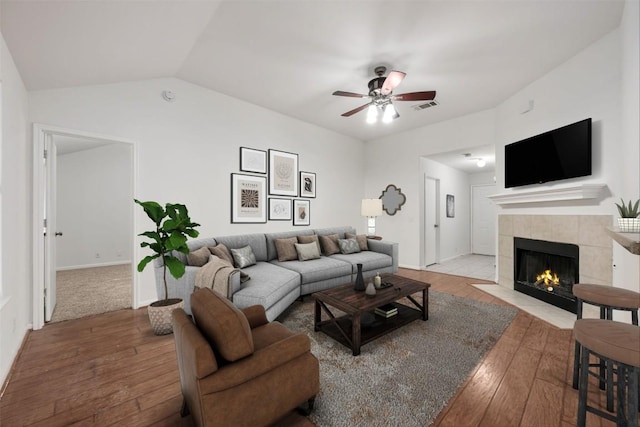 223 Keystone Loop, Kyle, TX 78640 - living area featuring a tile fireplace, hardwood / wood-style flooring, a ceiling fan, and vaulted ceiling