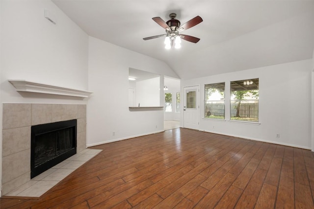 223 Keystone Loop, Kyle, TX 78640 - unfurnished living room with a fireplace, vaulted ceiling, a ceiling fan, and wood finished floors