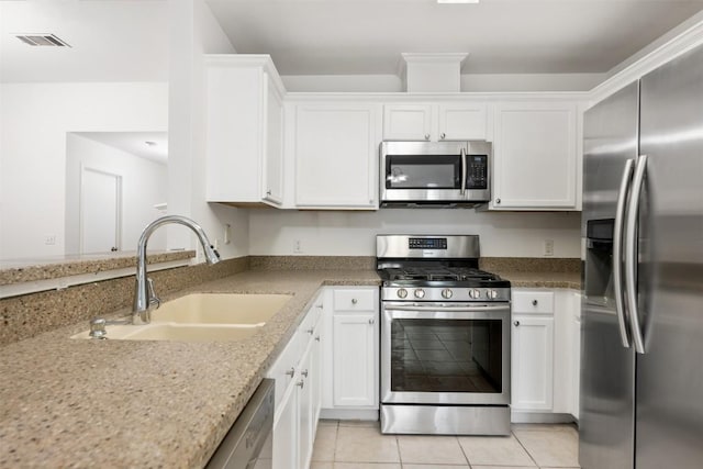 223 Keystone Loop, Kyle, TX 78640 - kitchen with stainless steel appliances, white cabinets, light tile patterned floors, and light stone counters