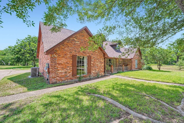 3610 Quiette Dr, Austin, TX 78754 - view of front of house featuring roof with shingles, a front lawn, brick siding, and central AC unit