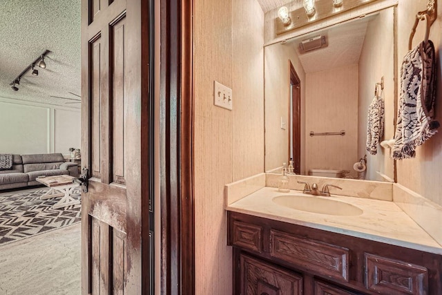 3610 Quiette Dr, Austin, TX 78754 - bathroom featuring track lighting, vanity, toilet, and a textured ceiling