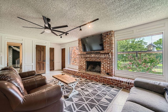 3610 Quiette Dr, Austin, TX 78754 - living area with a decorative wall, a ceiling fan, a textured ceiling, and a fireplace