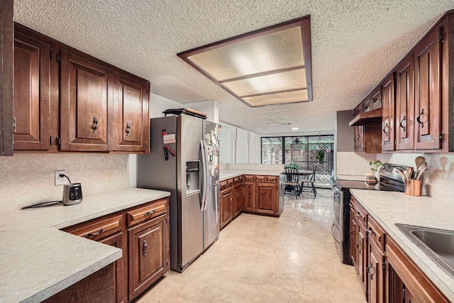 3610 Quiette Dr, Austin, TX 78754 - kitchen with appliances with stainless steel finishes, a textured ceiling, light countertops, a sink, and under cabinet range hood
