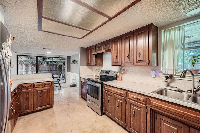 3610 Quiette Dr, Austin, TX 78754 - kitchen featuring appliances with stainless steel finishes, a sink, a textured ceiling, light countertops, and concrete floors