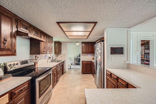 3610 Quiette Dr, Austin, TX 78754 - kitchen featuring appliances with stainless steel finishes, a sink, a textured ceiling, light countertops, and decorative backsplash