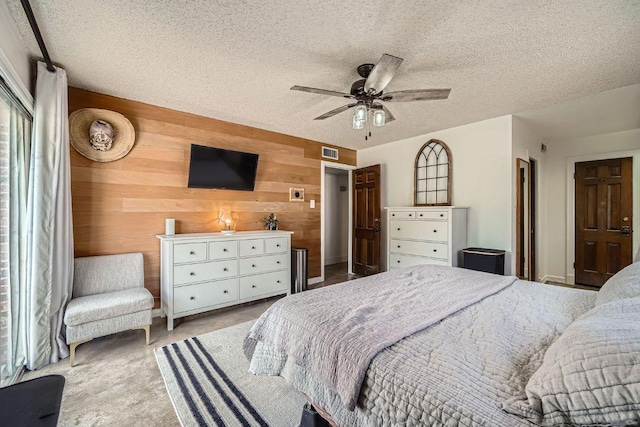 3610 Quiette Dr, Austin, TX 78754 - carpeted bedroom with wood walls, a textured ceiling, and ceiling fan
