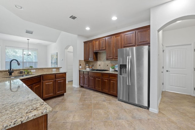 16413 Broadbay Dr, Austin, TX 78717 - kitchen featuring stainless steel fridge with ice dispenser, arched walkways, tasteful backsplash, a sink, and black gas stovetop