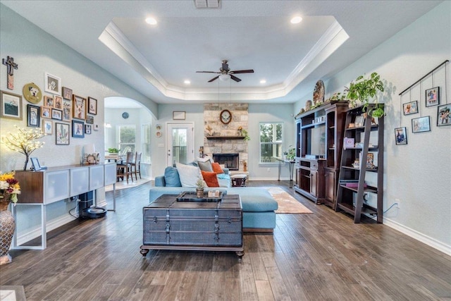 1033 Castleway Rd, New Braunfels, TX 78132 - living room with ceiling fan, wood finished floors, a raised ceiling, a fireplace, and arched walkways