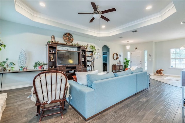 1033 Castleway Rd, New Braunfels, TX 78132 - living room with a tray ceiling, ceiling fan, wood finished floors, arched walkways, and ornamental molding