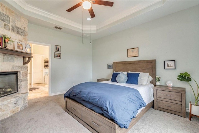 1033 Castleway Rd, New Braunfels, TX 78132 - bedroom with crown molding, carpet flooring, a stone fireplace, a tray ceiling, and ceiling fan
