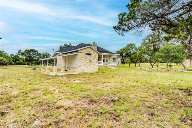 1033 Castleway Rd, New Braunfels, TX 78132 - view of side of home with stone siding, a lawn, a chimney, and a porch