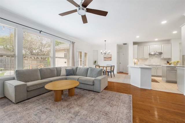 11817 Lake Stone Dr, Austin, TX 78738 - living room with a chandelier, ceiling fan, light wood-type flooring, and recessed lighting