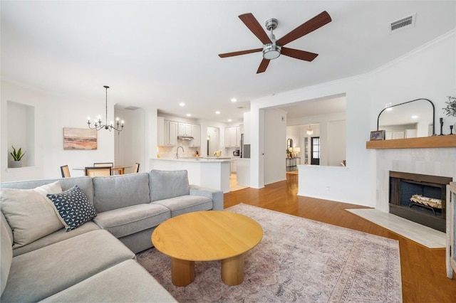11817 Lake Stone Dr, Austin, TX 78738 - living area with ceiling fan, light wood-style flooring, a chandelier, a fireplace, and recessed lighting