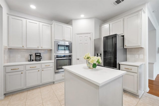 11817 Lake Stone Dr, Austin, TX 78738 - kitchen featuring appliances with stainless steel finishes, light tile patterned flooring, backsplash, light countertops, and recessed lighting