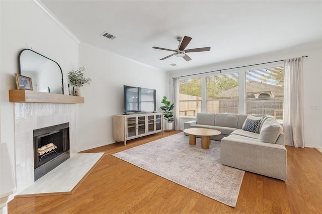 11817 Lake Stone Dr, Austin, TX 78738 - living room featuring ceiling fan, crown molding, a tile fireplace, wood finished floors, and baseboards