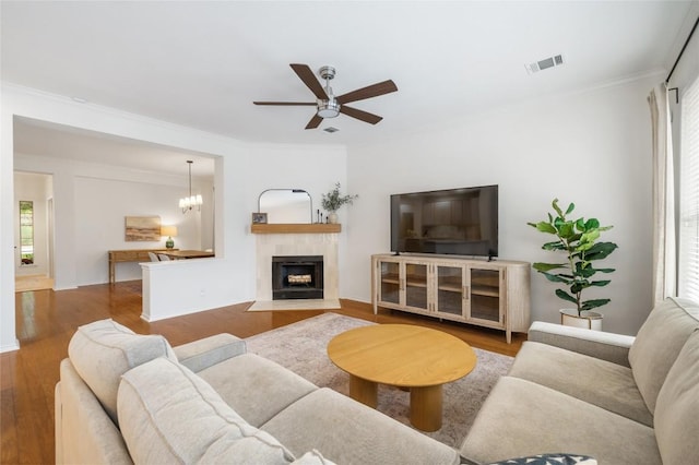 11817 Lake Stone Dr, Austin, TX 78738 - living room with wood finished floors, ceiling fan, ornamental molding, a tiled fireplace, and baseboards
