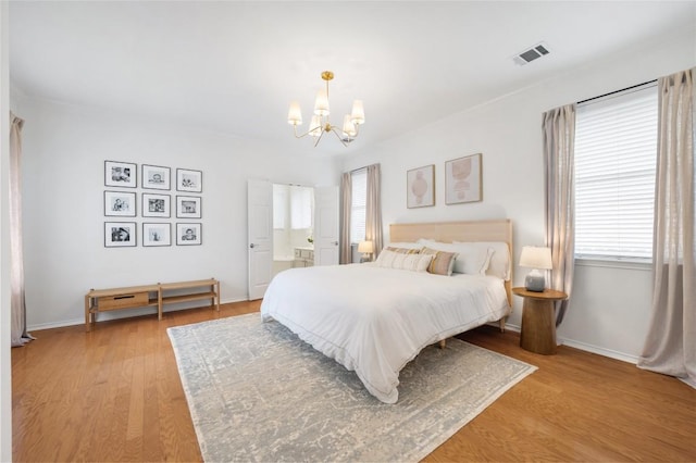11817 Lake Stone Dr, Austin, TX 78738 - bedroom with a chandelier, light wood-style floors, and baseboards