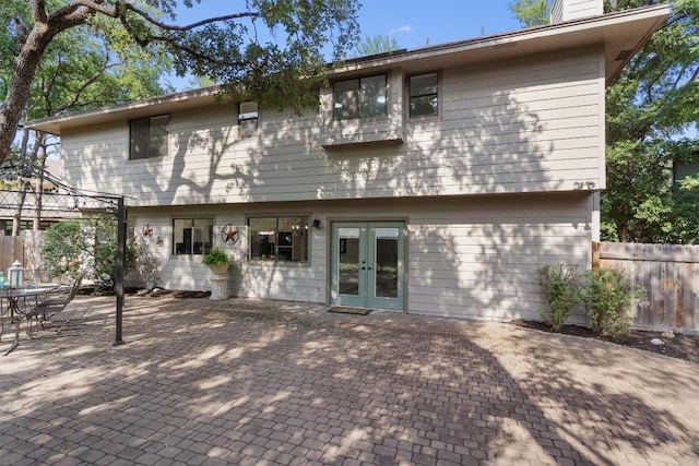 7915 Petaca Trl, Austin, TX 78729 - rear view of house with french doors, a patio, and a chimney