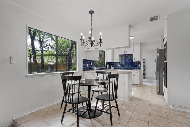 7915 Petaca Trl, Austin, TX 78729 - dining room with a chandelier, light tile patterned floors, and baseboards