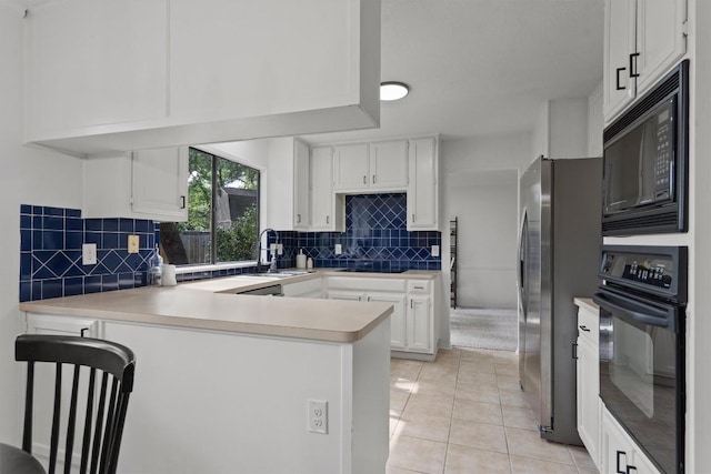 7915 Petaca Trl, Austin, TX 78729 - kitchen featuring black appliances, a sink, a peninsula, light countertops, and white cabinets