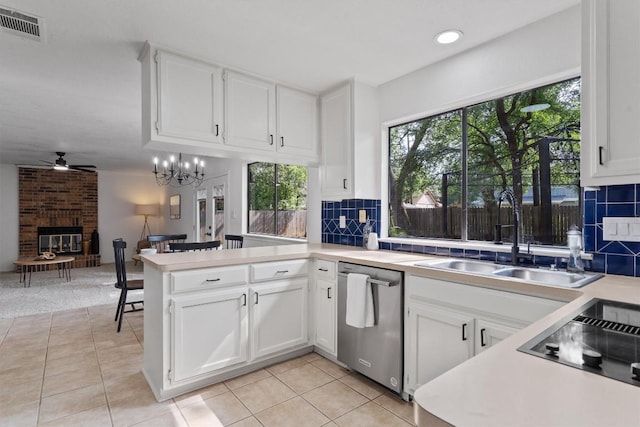 7915 Petaca Trl, Austin, TX 78729 - kitchen featuring stainless steel dishwasher, ceiling fan, a fireplace, black electric cooktop, and light countertops