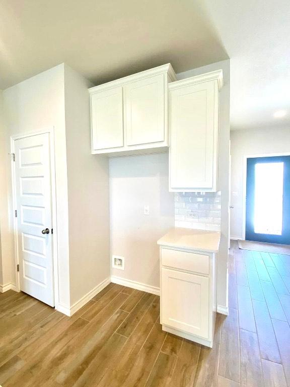 11713 Caithness Way, Austin, TX 78754 - kitchen with wood finished floors, baseboards, and white cabinets