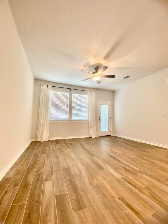 11713 Caithness Way, Austin, TX 78754 - unfurnished room with wood finished floors, ceiling fan, and baseboards