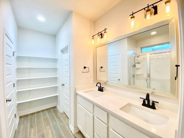11713 Caithness Way, Austin, TX 78754 - bathroom featuring a shower stall, double vanity, wood finished floors, and recessed lighting