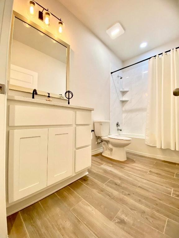 11713 Caithness Way, Austin, TX 78754 - full bath featuring toilet, shower / bath combination with curtain, vanity, wood finished floors, and recessed lighting