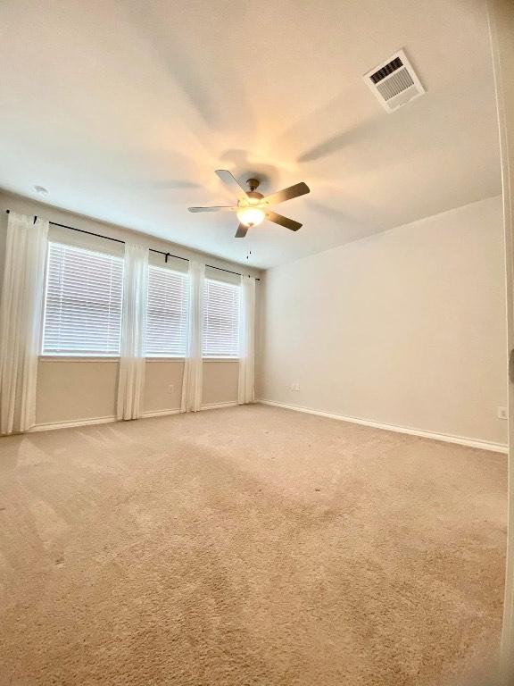 11713 Caithness Way, Austin, TX 78754 - spare room with a ceiling fan, light colored carpet, and baseboards